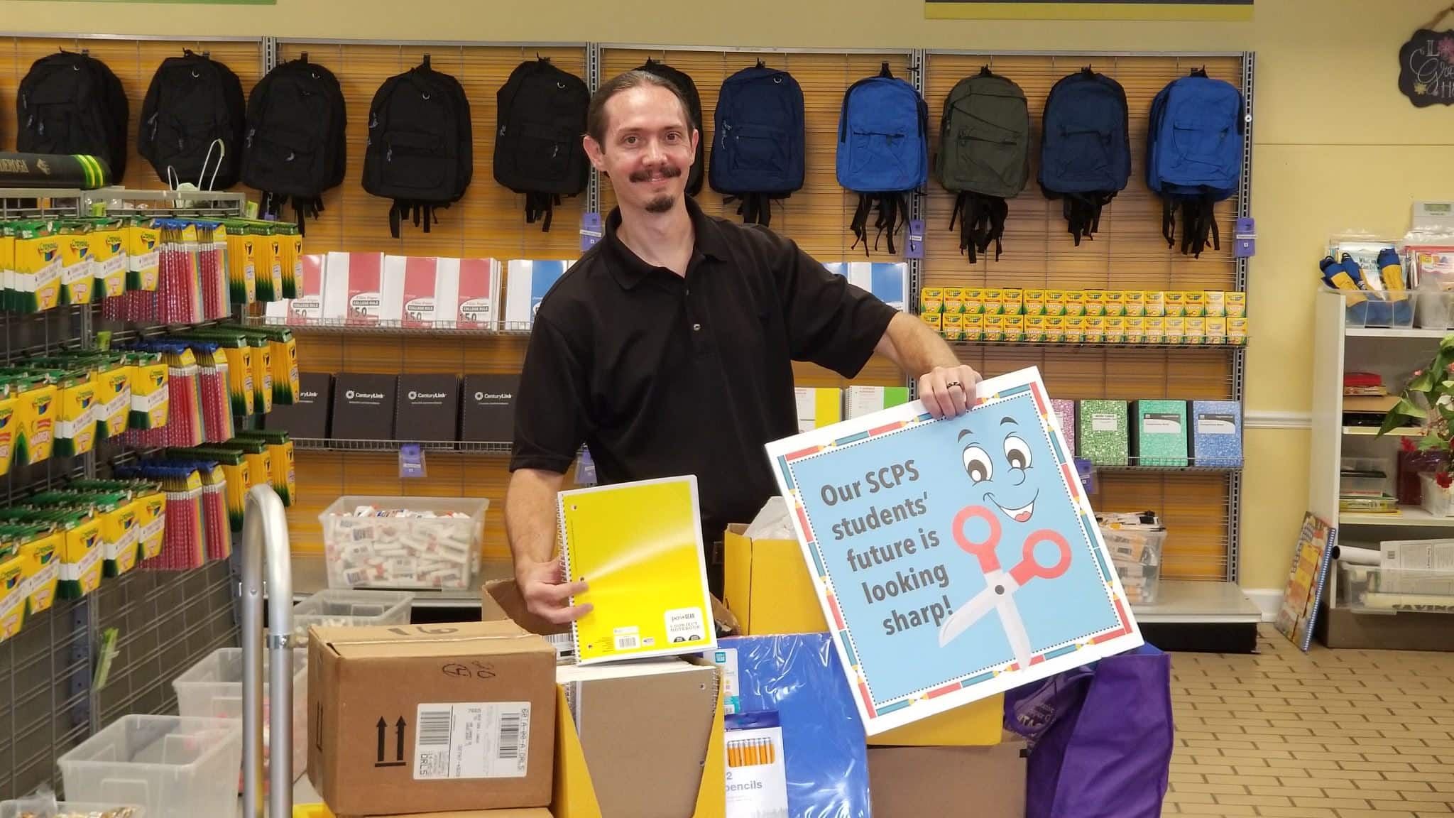 Sean Elser holding school supplies for kids